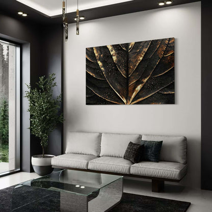 Canvas schilderij met zwart blad en gouden details boven bankstel.