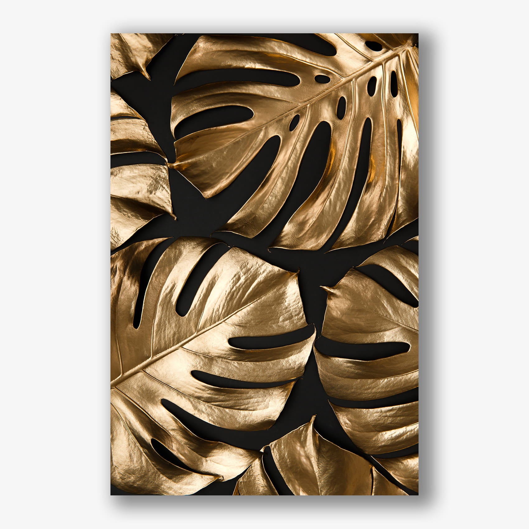 Muurdecoratie met meerdere gouden monstera bladeren op zwarte achtergrond.