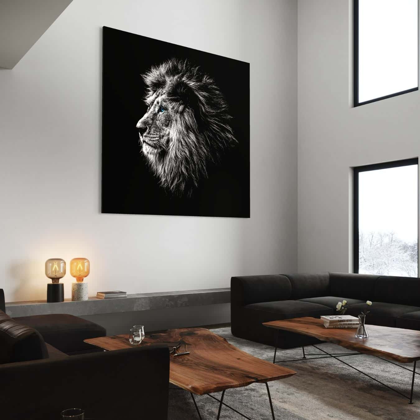 Groot zwart wit schilderij van leeuw met blauwe ogen in luxe hoge woonkamer.